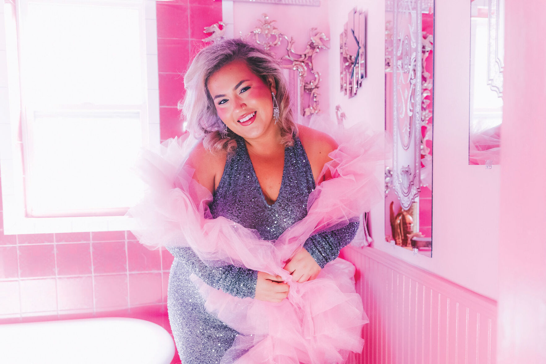 Molly Grace press photo artist in rhinestone outfit poses in bright pink bathroom